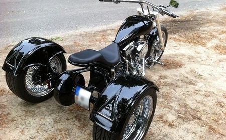 Schwarzes Motorrad mit drei Rädern von hinten